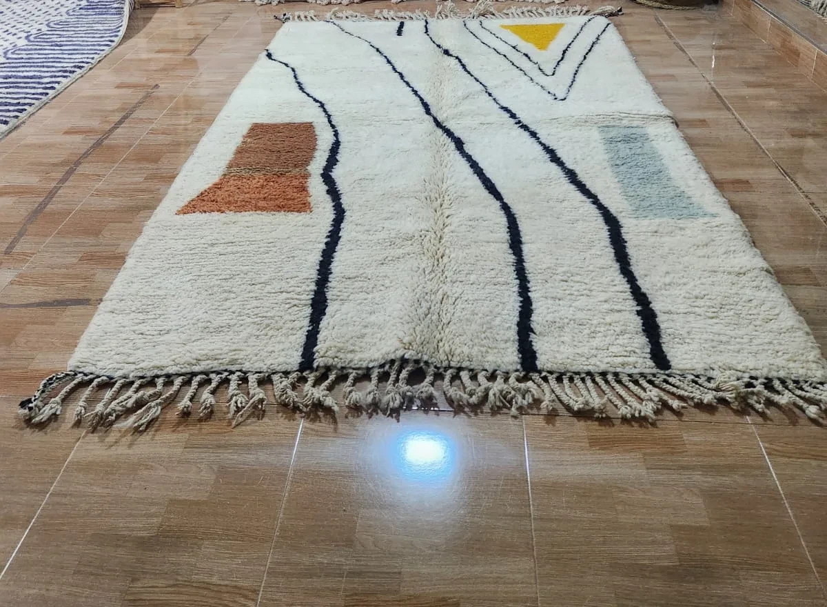 Ivory Moroccan rug with black flowing vertical line pattern and rust, sage and mustard color-block accents