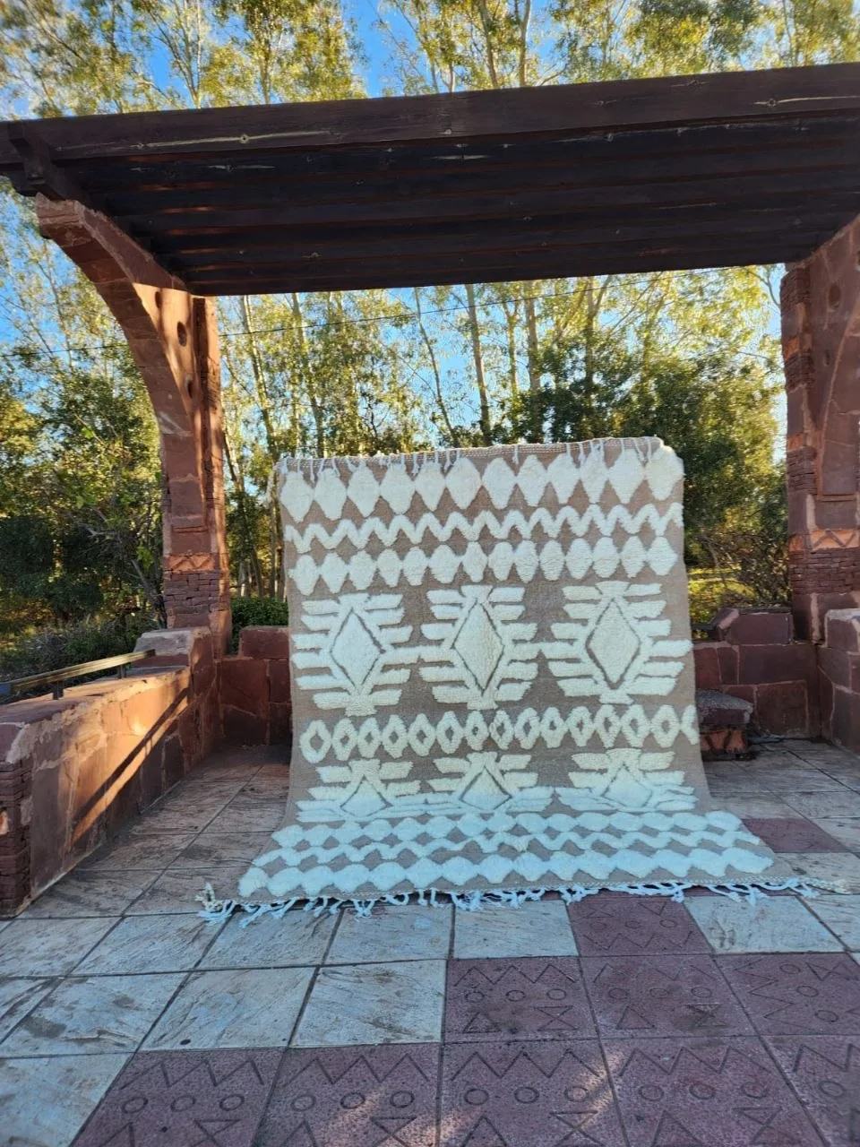Ivory Beni Ourain rug with sage green diamond geometric pattern outdoors in olive grove