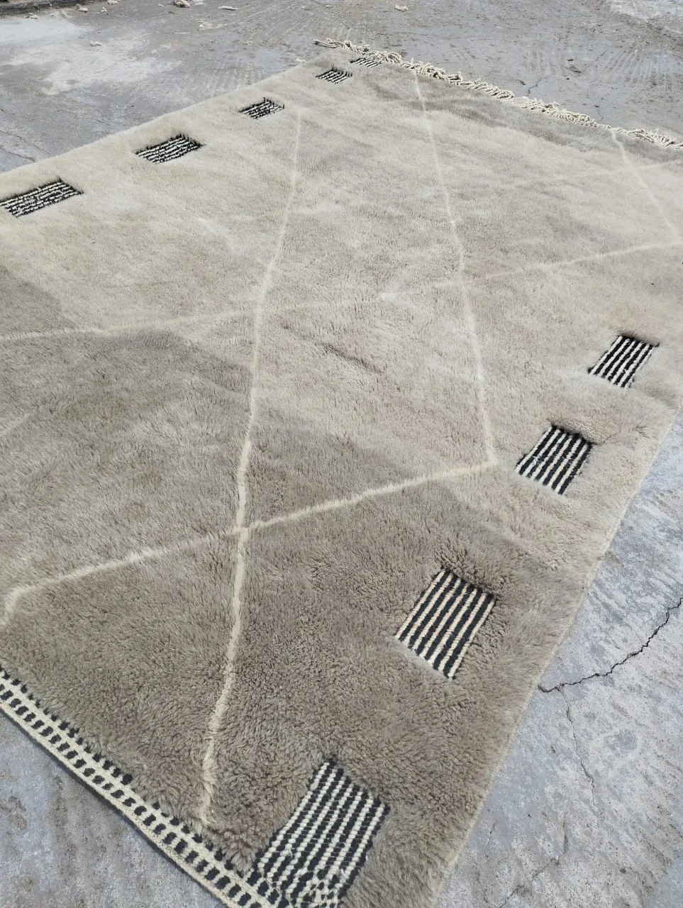 Moroccan rug displayed outdoors against traditional architecture