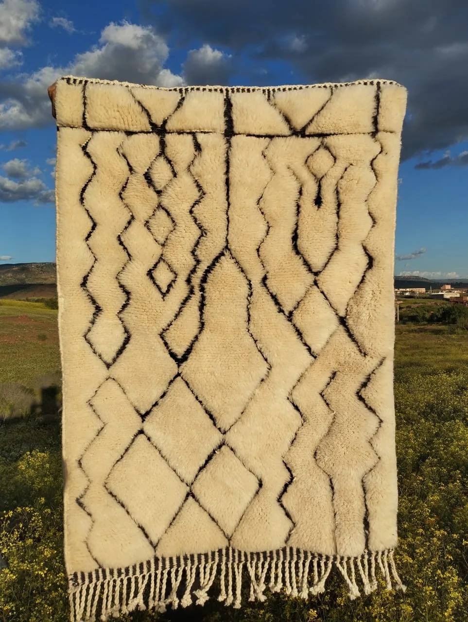 Ivory Moroccan rug with bold charcoal diamond lattice pattern, scalloped top border and central diamond medallion