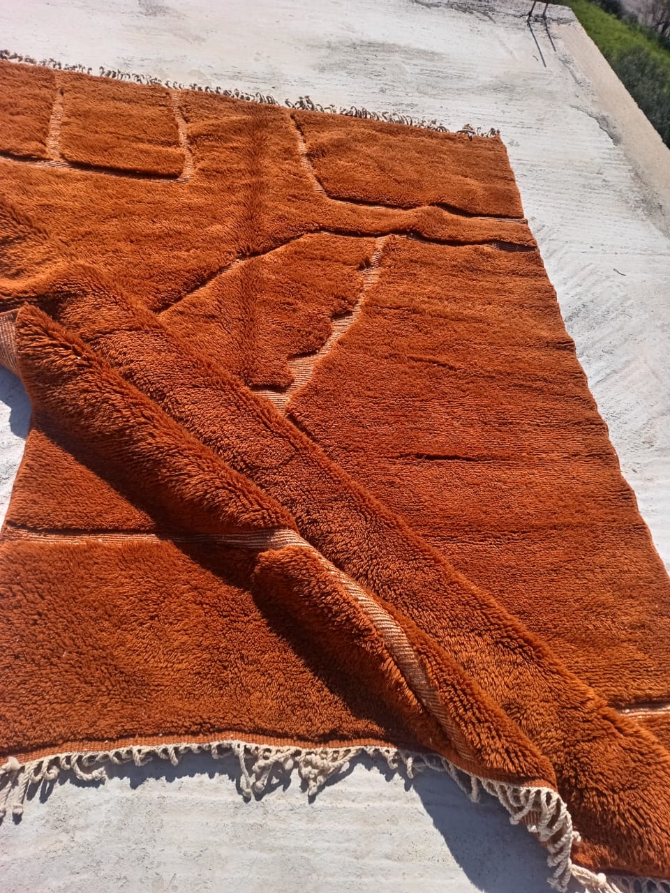Deep rust terracotta Moroccan rug with tonal carved geometric lines and fringe
