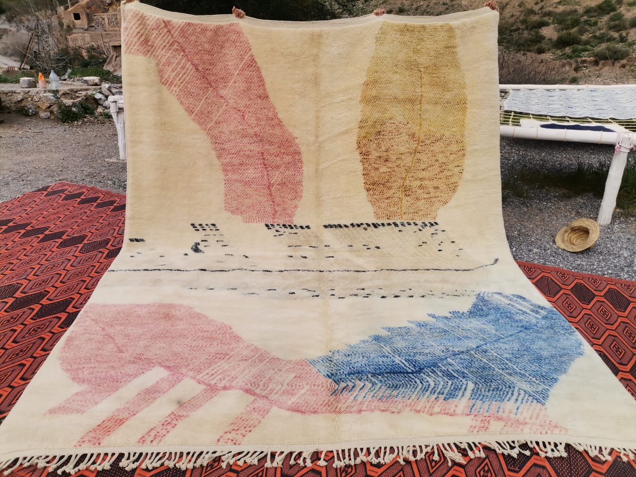 Ivory Moroccan rug with large organic leaf shapes in dusty pink, amber yellow and denim blue