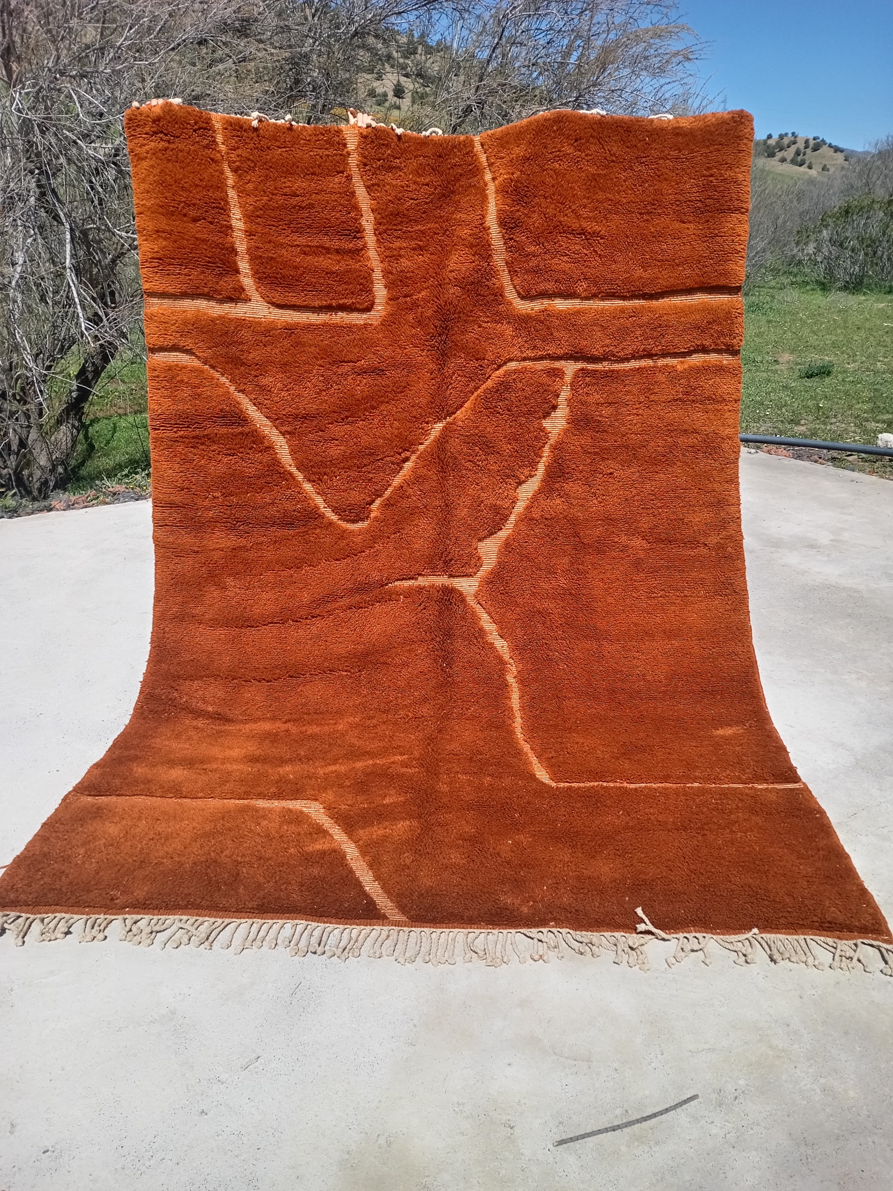 Deep terracotta Moroccan rug with subtle ivory carved and embossed line pattern