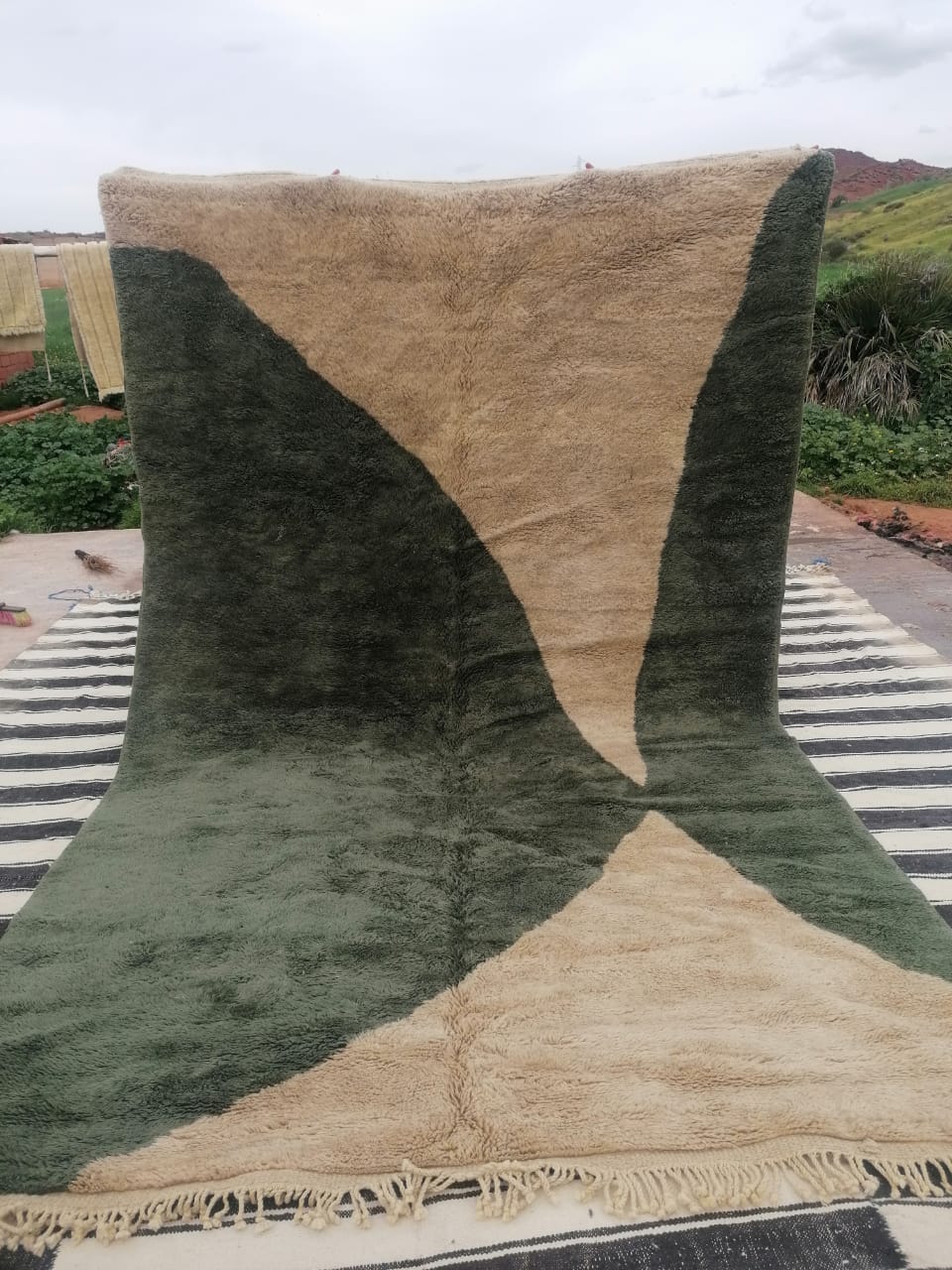 Moroccan rug with bold forest green abstract wave and arch shapes on natural ivory