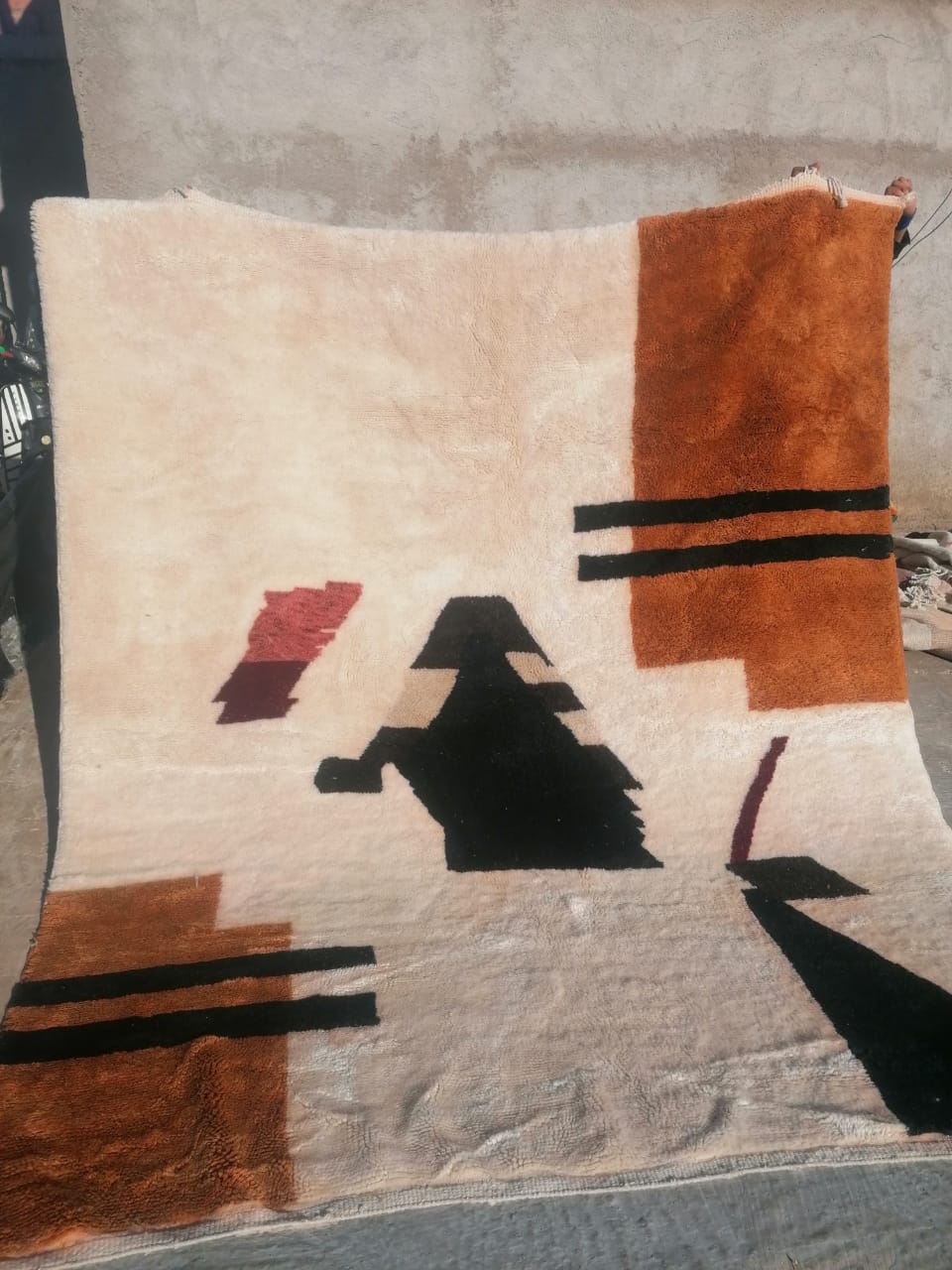 Ivory Moroccan rug with bold rust amber rectangular panel and large black abstract geometric shape