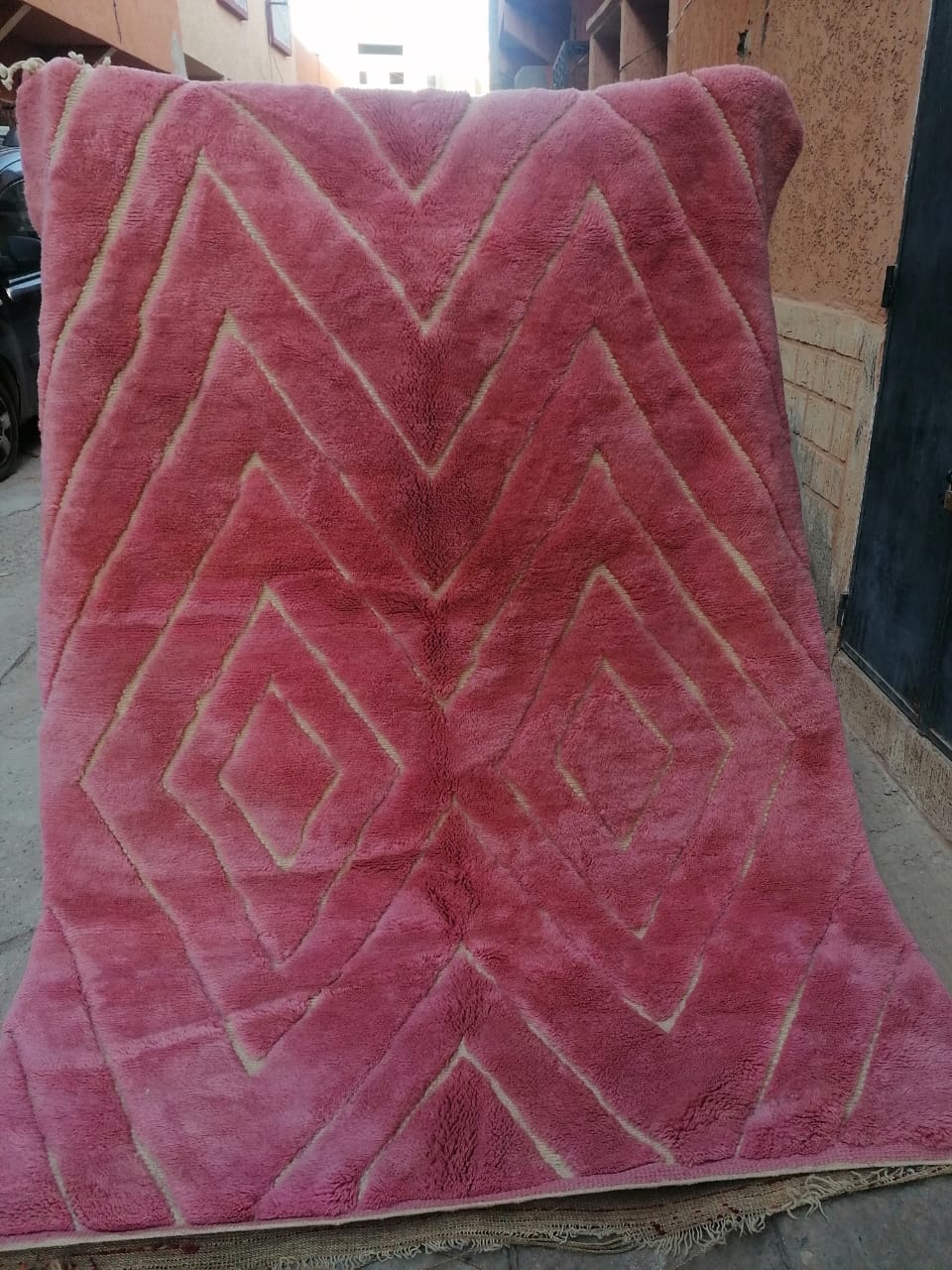 Deep rose pink Moroccan rug with ivory nested diamond lozenge pattern