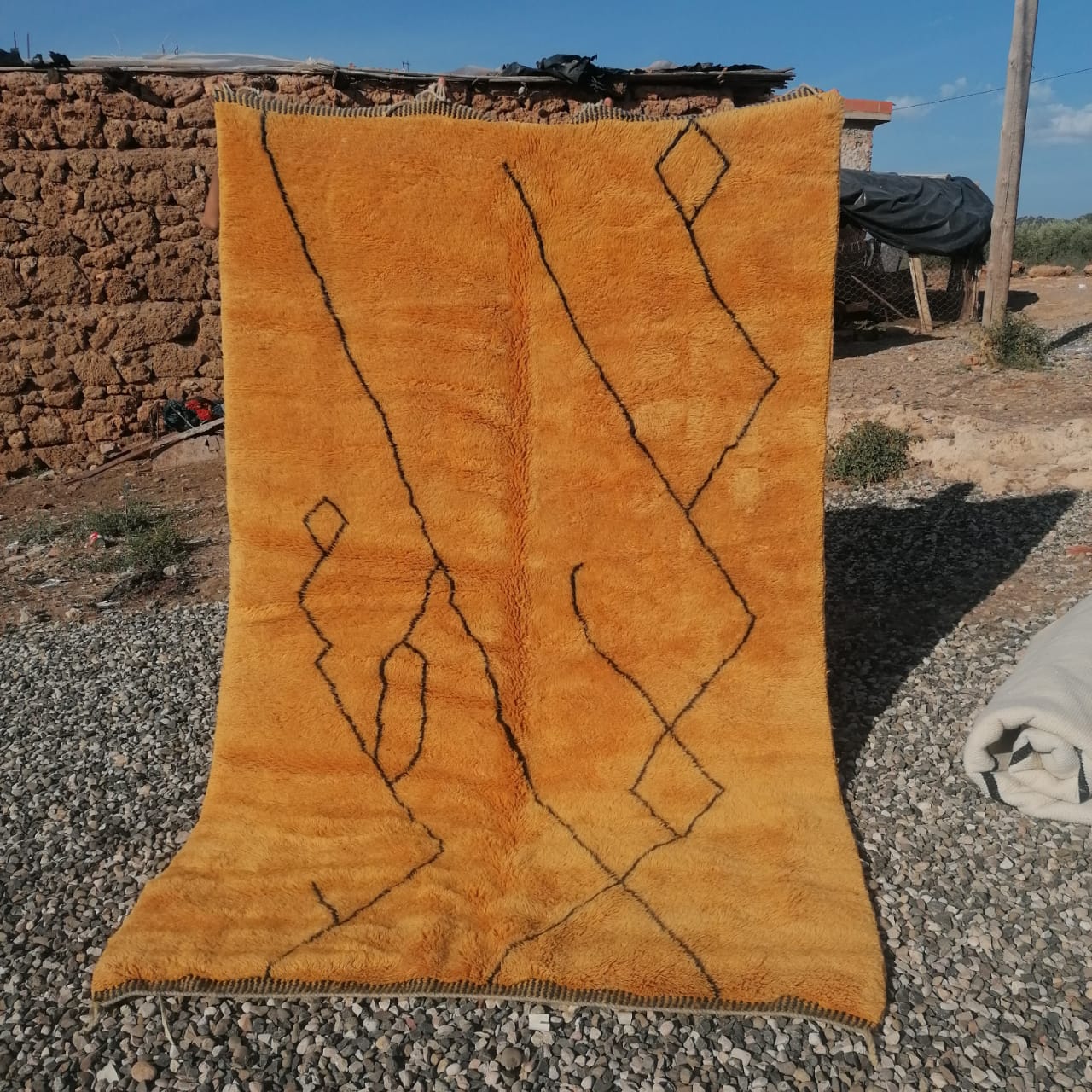 Saffron amber Moroccan rug with black hand-drawn geometric lines and diamond motifs