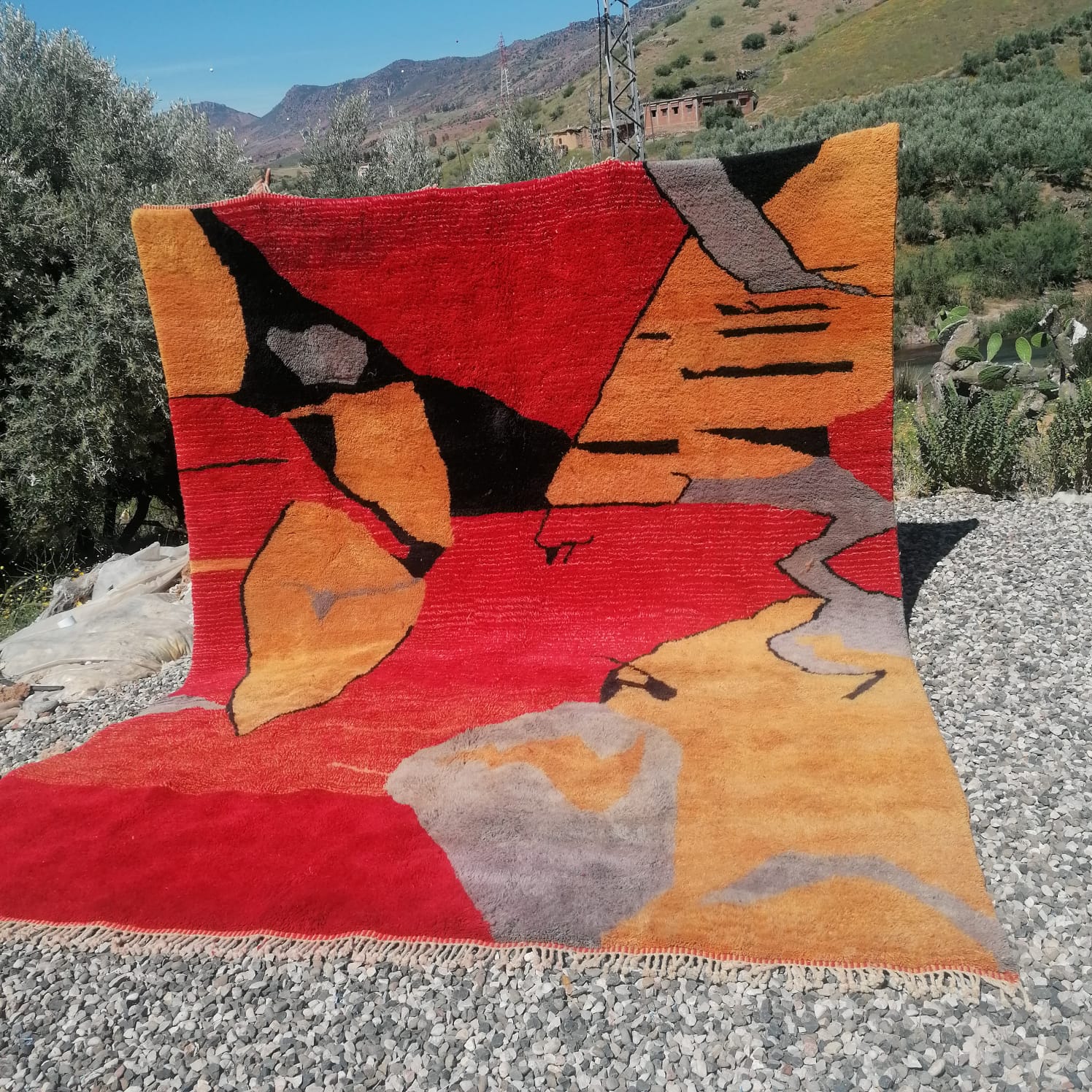 Bold Moroccan rug with vivid abstract landscape in red, burnt orange, black and warm grey