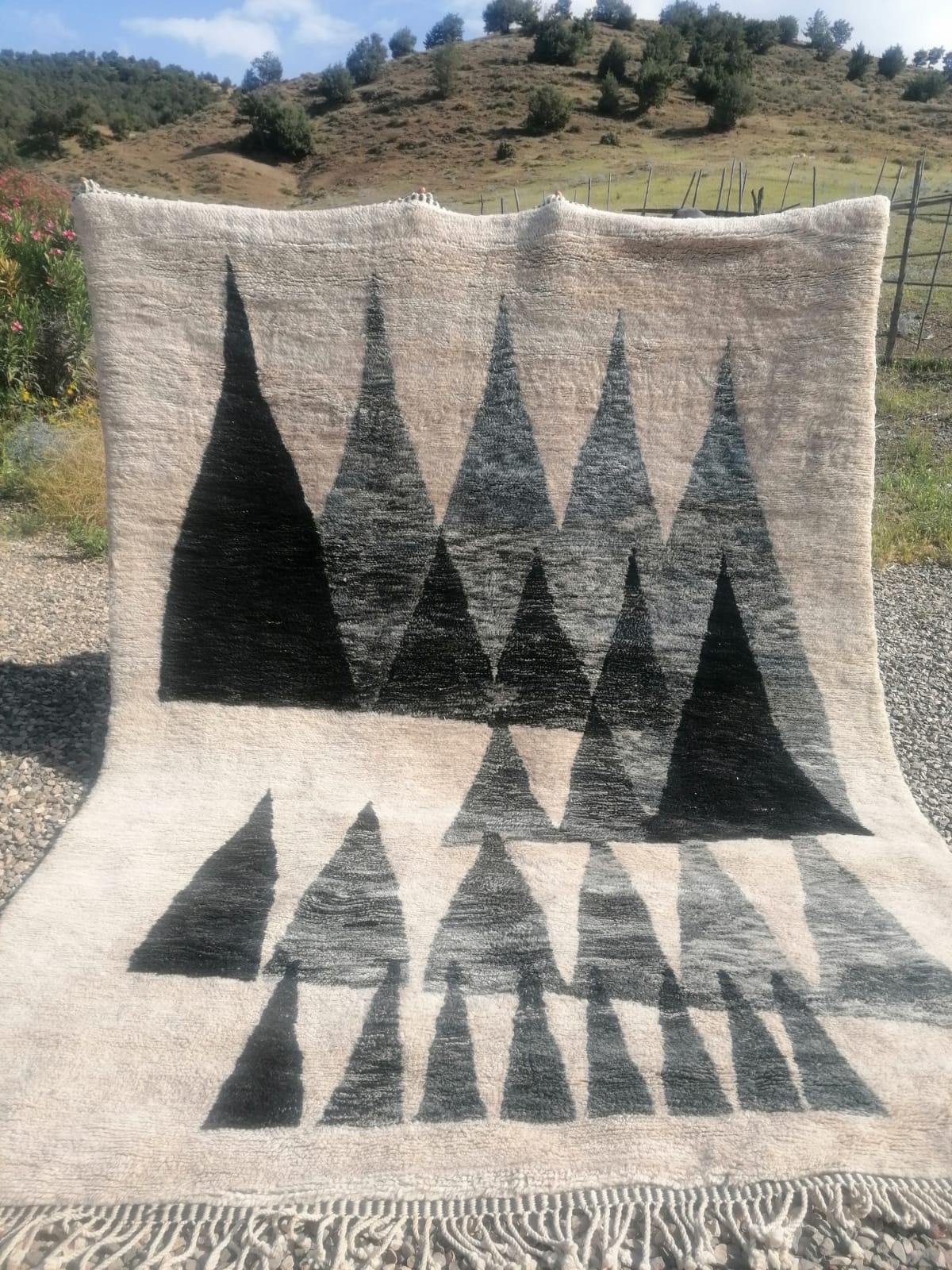 Moroccan rug with dramatic charcoal triangle mountain silhouettes on ivory ground