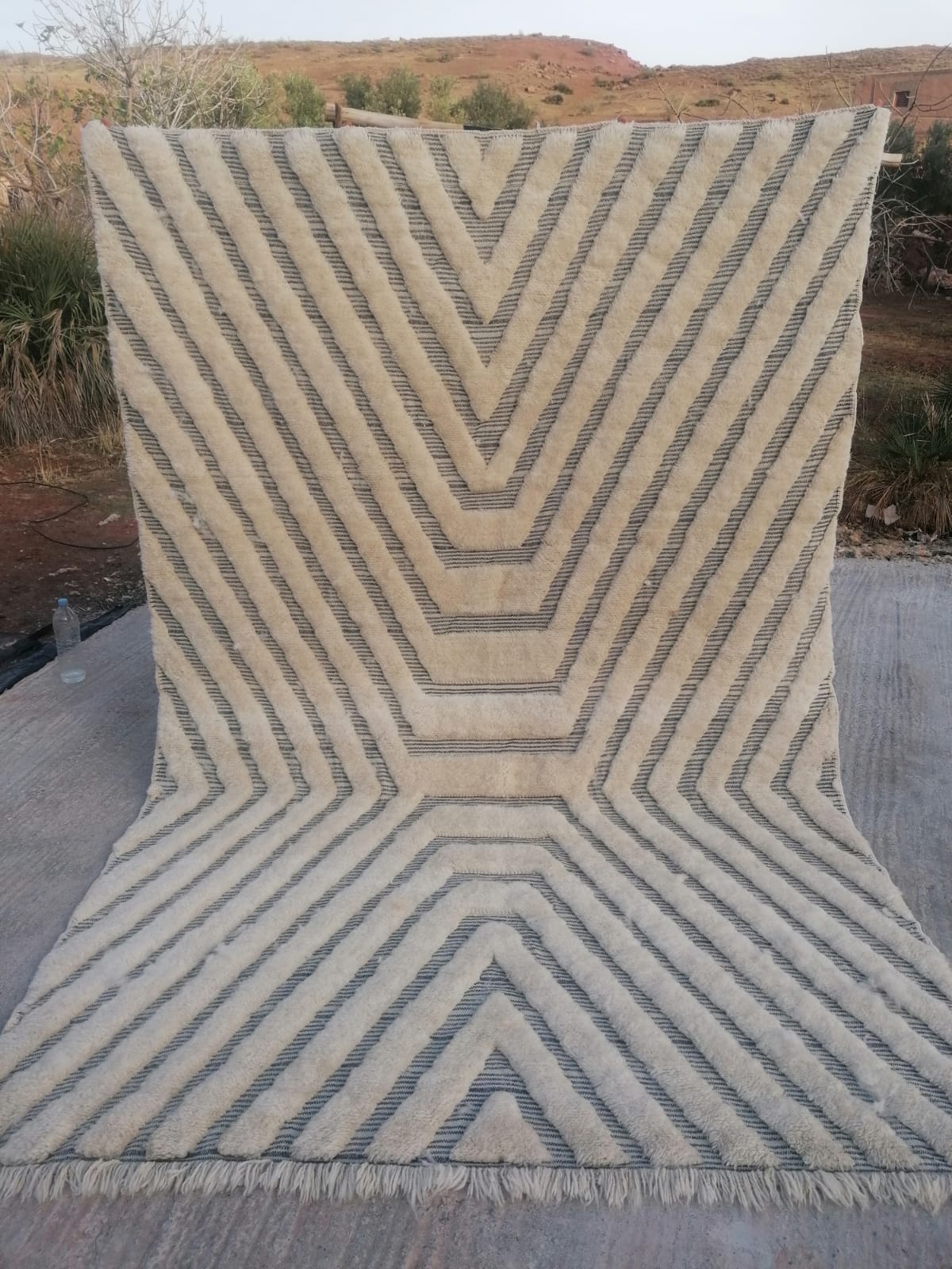 Ivory Moroccan rug with nested charcoal chevron and arrow geometric repeat pattern