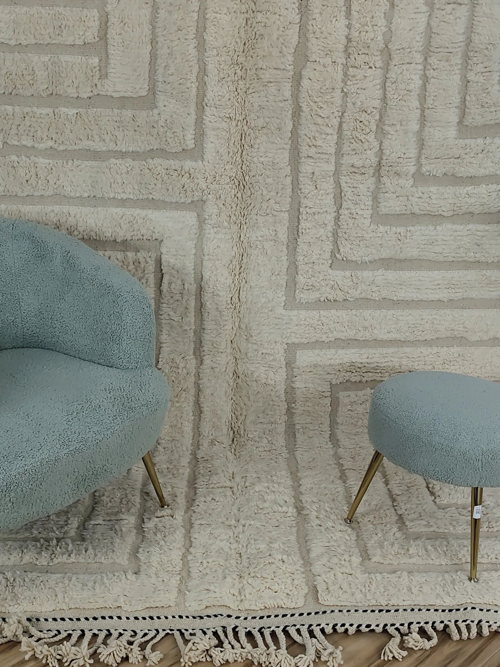 Latifa — a close view of the carved maze between chair and stool, Contemporary Moroccan rug in ivory, hand-knotted wool, view 8 of 21