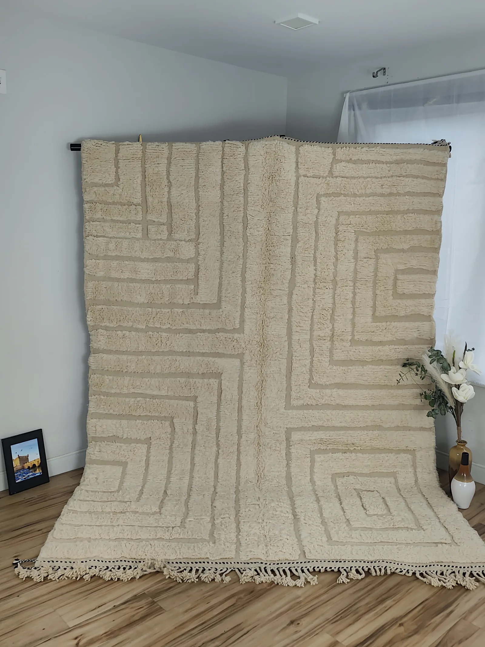 Latifa — hung from a rail beside white flowers, Contemporary rug handwoven in Morocco, view 6 of 21