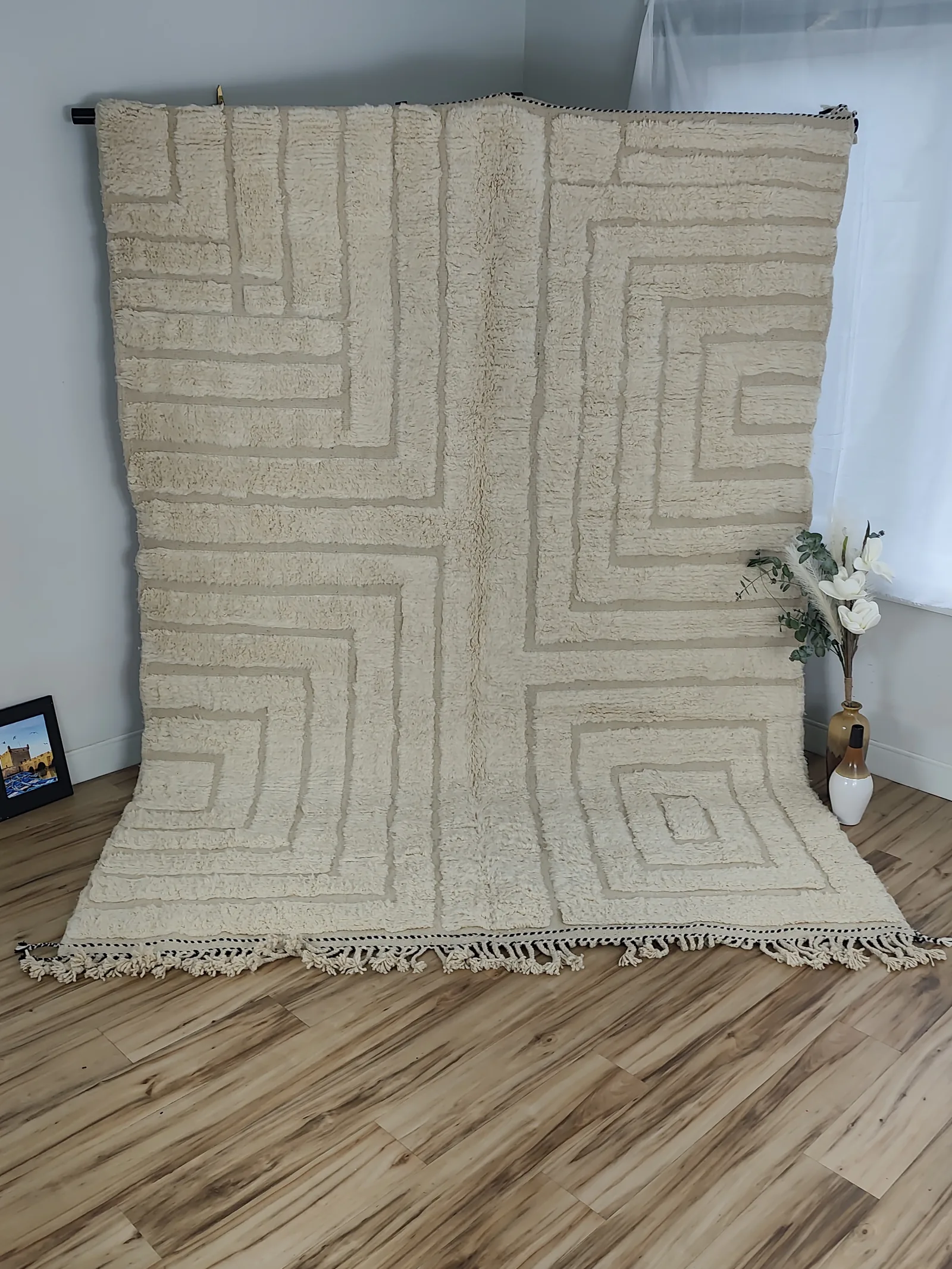 Latifa — hung from a rail beside eucalyptus, fringe on the floor, 271 × 200 cm Contemporary Moroccan rug in ivory, view 2 of 21