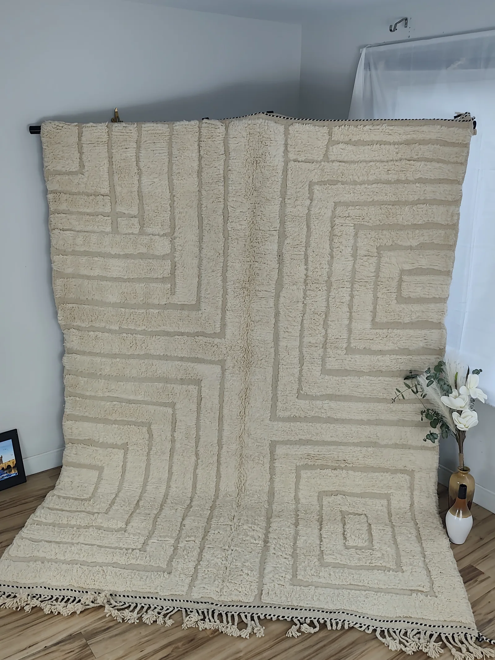 Latifa — hung from a rail, fringe pooling on the floor, the corner-flip reveals a natural linen flat-woven back, 271 × 200 cm, view 19 of 21