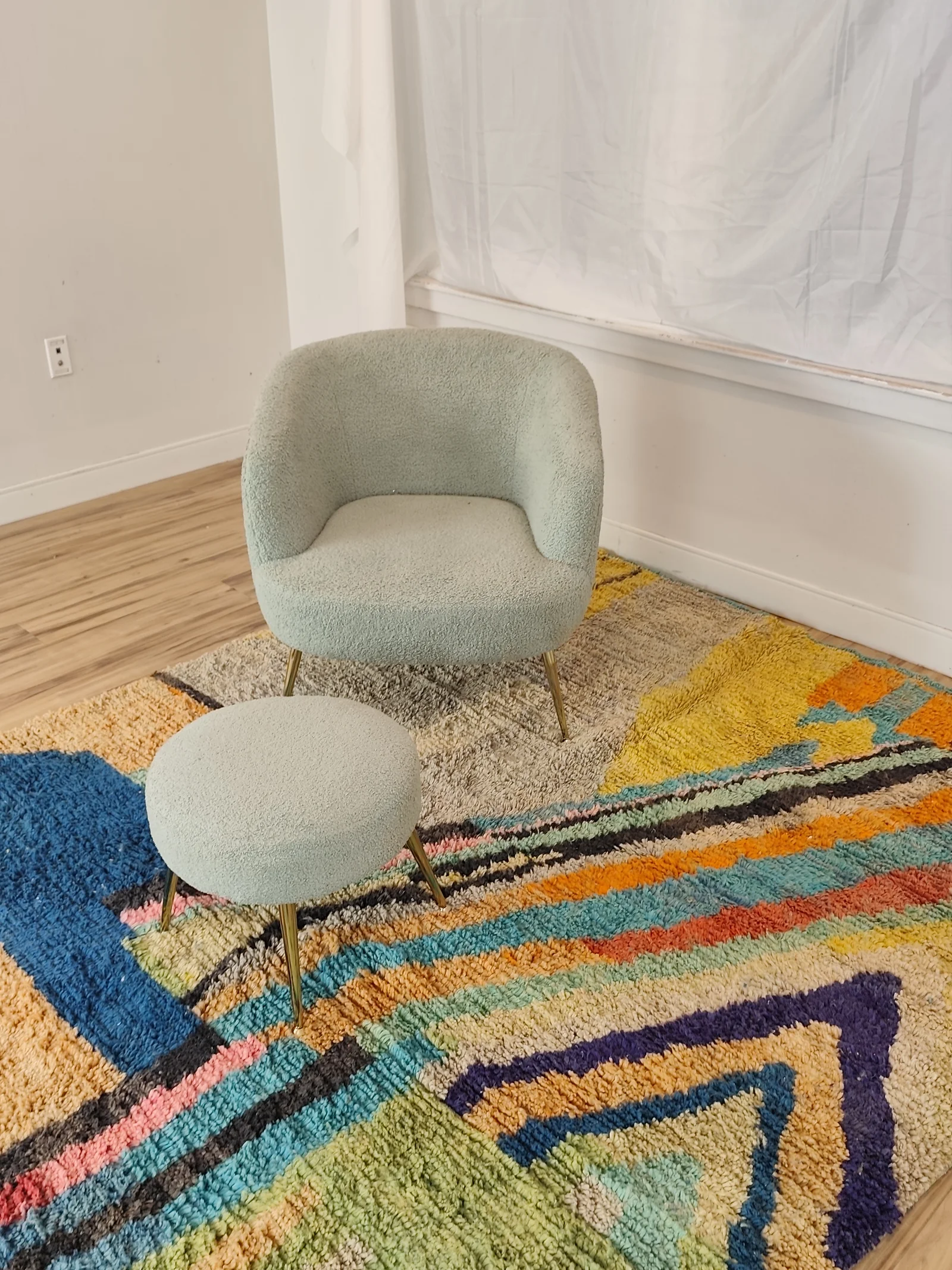 Soukaina — a boucle chair and stool standing on the rug, Boujaad Moroccan rug in teal, blush and mustard, hand-knotted wool, view 6 of 20