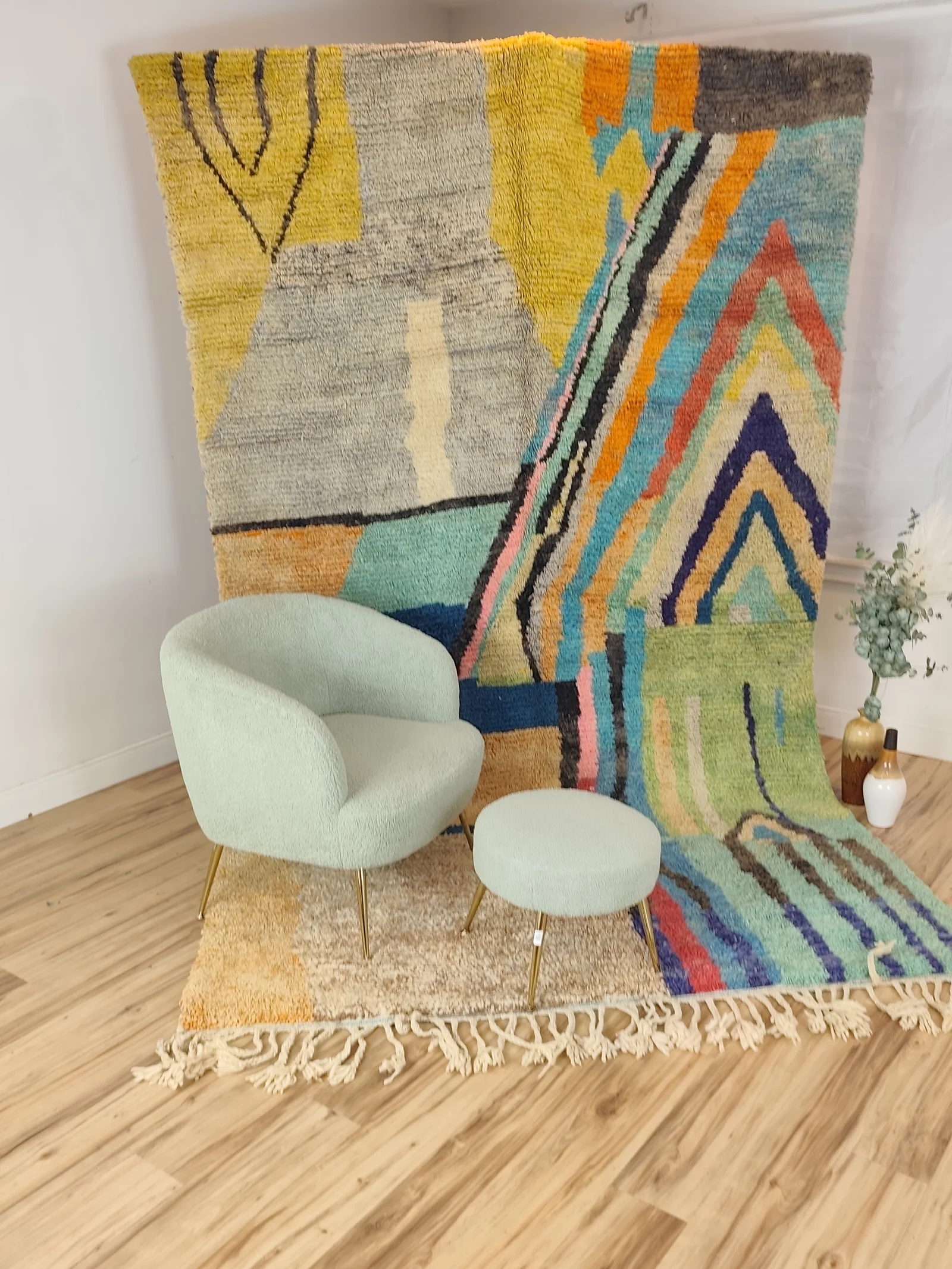 Soukaina — hung from a rail with a boucle chair and stool in front, an abstract Boujaad in teal, blush and mustard, with bold diagonal bands cutting across a cream ground, high pile, view 15 of 20