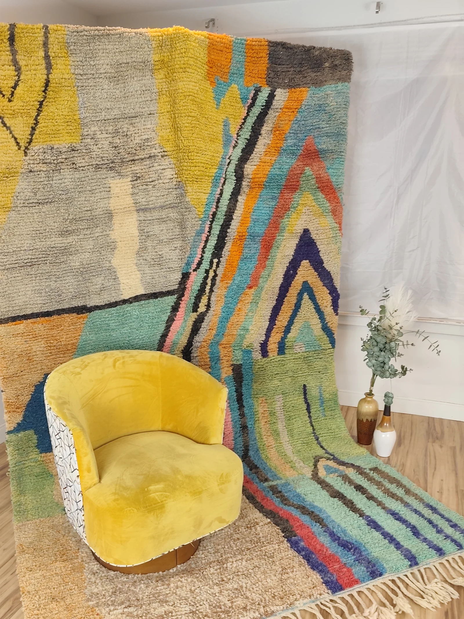 Soukaina — an ochre chair against the hung rug, seen close, modern and painterly, unlike any other piece, view 20 of 20