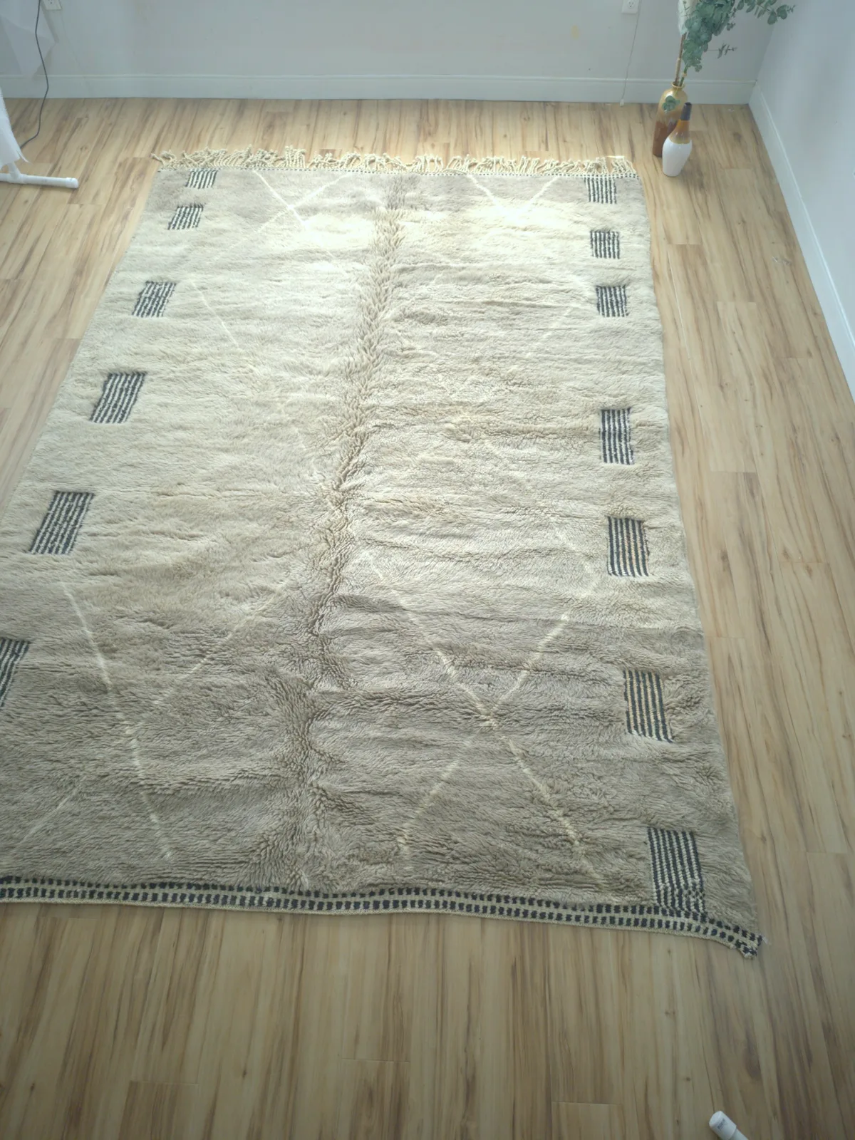 Warm grey Moroccan rug with groups of black tally-mark stripes and black end-stripes