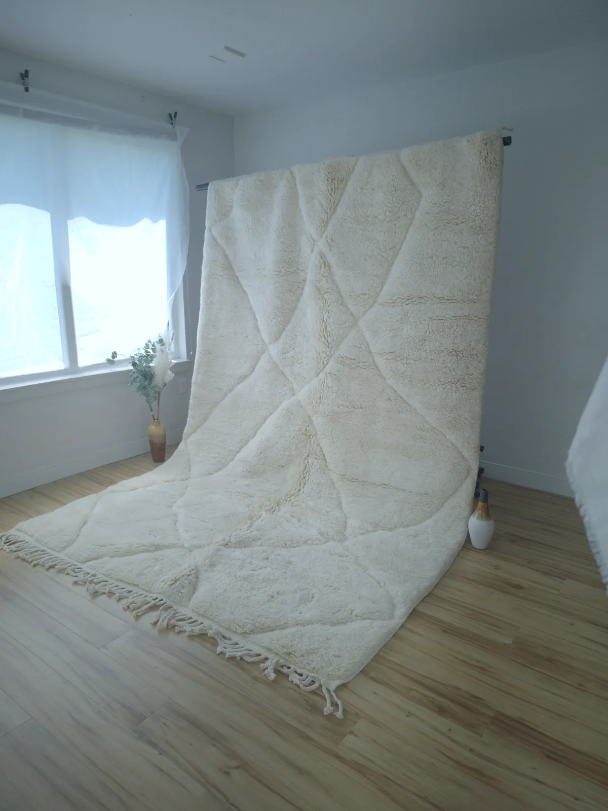 Classic ivory Beni Ourain rug with soft traditional diamond lattice and braided fringe